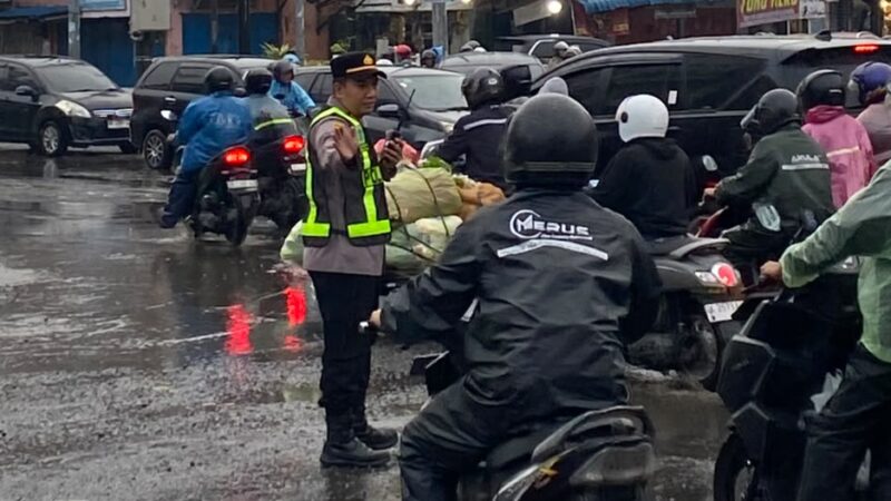 Ditengah guyuran Hujan, Kapolsek Sunggal Atur Lalin Pagi Hari DiWilayahnya