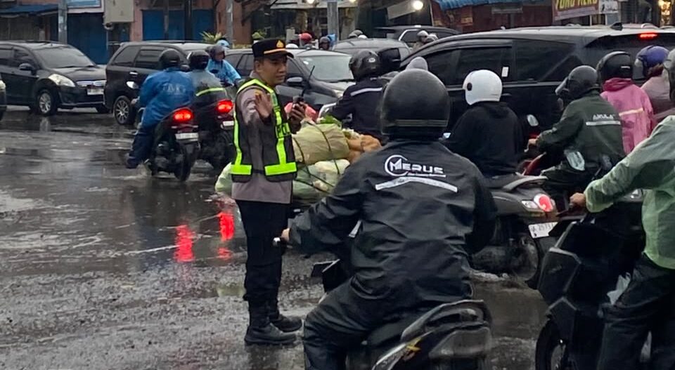 Ditengah guyuran Hujan, Kapolsek Sunggal Atur Lalin Pagi Hari DiWilayahnya